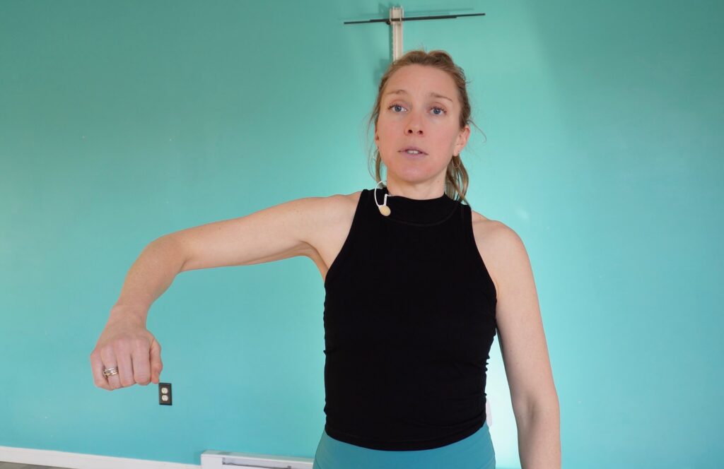 Dr. Chloe with her right arm out the to side, elbow up and wrist down - how to not do the rotator cuff exercise properly